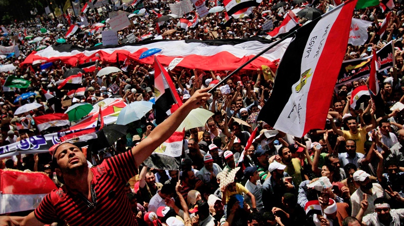A protester waves an Egyptian flag that reads 'We Love Egypt' during a demonstration after Friday prayers in Tahrir Square where many have set up protest tent camps in the main city square in Cairo, Egypt, Friday July 29, 2011. (AP / Khalil Hamra)