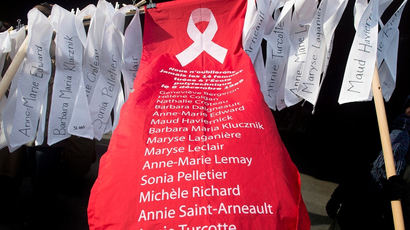 The names of the 14 women gunned down at Ecole Polytechnique in 1989 are shown at a demonstration to highlight violence against women in Montreal, Dec. 6, 2013. (Graham Hughes / THE CANADIAN PRESS)