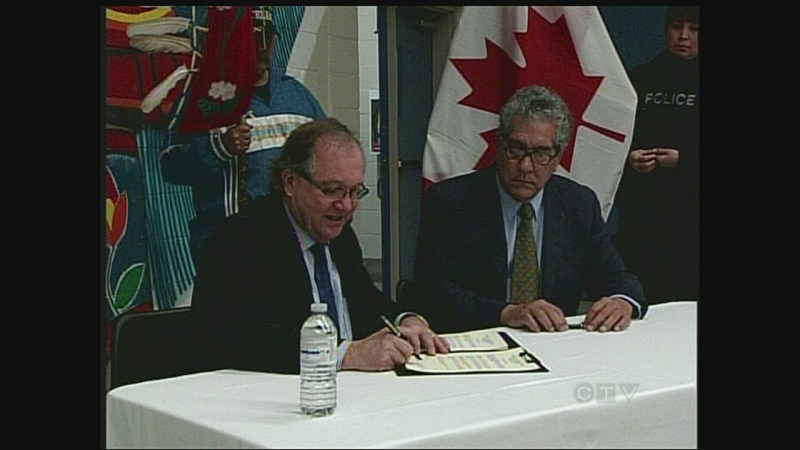 Aboriginal Affairs and Northern Development Minister Bernard Valcourt, left, and Chippewas of the Thames First Nation Chief Joe Miskokomon sign a land claim agreement on Monday, Dec. 9, 2013.