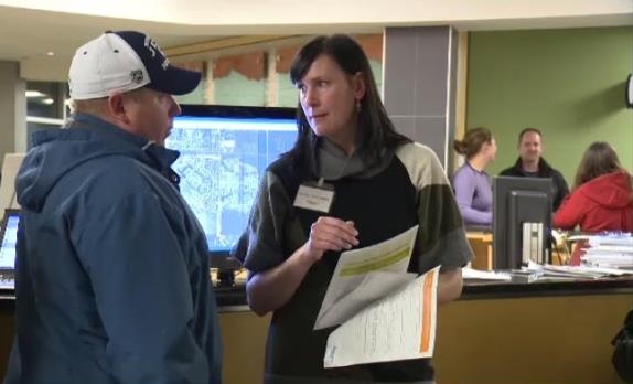 A Manitoba Hydro representative answers questions from a Sage Creek resident. 