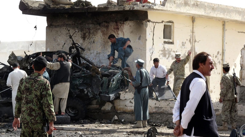 Afghan police officers inspect a wrecked police vehicle at the entrance of the police headquarters in Lashkar Gah, Helmand province, southern Afghanistan, Sunday, July 31, 2011. A suicide bomber blew himself up Sunday at the gate of the police headquarters, killing more than ten people in the city where Afghans have recently taken control of security. (AP Photo)