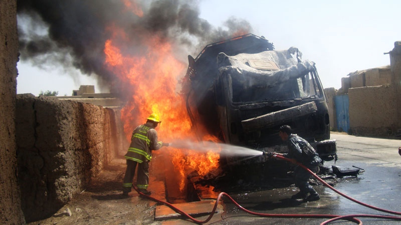 An Afghan police officer, right, and firefighter try to extinguish a fuel tanker carrying a fuel supply for NATO in Logar province, Afghanistan, Thursday, Aug. 4, 2011. (AP / Mohammed Obaid Ormur)