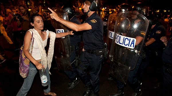 Police face a demonstrator in central Madrid on Thursday, Aug. 4, 2011.  (AP Photo/Arturo Rodriguez)