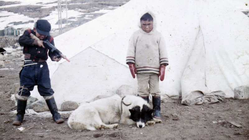 This handout photo supplied by Qikiqtani Inuit Association shows Inuit children and a dog taken in the summer of 1958 in Iqaluit, Nunavut. (HO - Qikiqtani Inuit Association / THE CANADIAN PRESS)