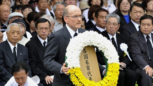 James Zumwalt, deputy chief of mission at the U.S. Embassy in Tokyo, carries a wreath to the altar set up in Nagasaki Peace Park in Nagasaki, southern Japan Tuesday, Aug. 9, 2011. (Kyodo News)