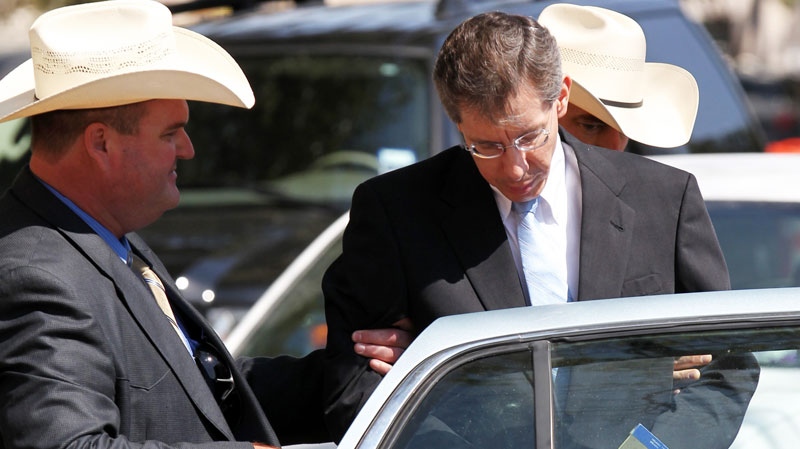 Warren Jeffs, leader of the Fundamentalist Church of Jesus Christ of Latter Day Saints, right, is placed into the back of a waiting car in San Angelo, Texas Tuesday, Aug. 9, 2011. (AP / The San Angelo Standard-Times, Patrick Dove)