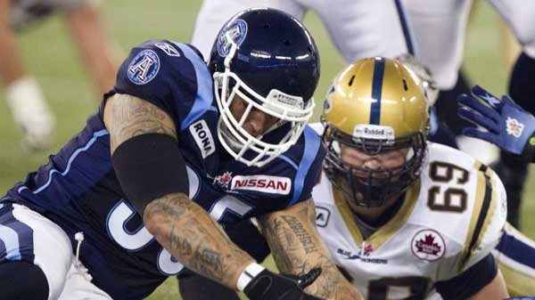 Toronto Argonauts linebacker Kevin Eiben (left) scoops up a fumble in front of Winnipeg Blue Bombers offensive lineman Glenn January (69) during first half CFL action in Toronto on Saturday, July 23, 2011. (Frank Gunn / THE CANADIAN PRESS)