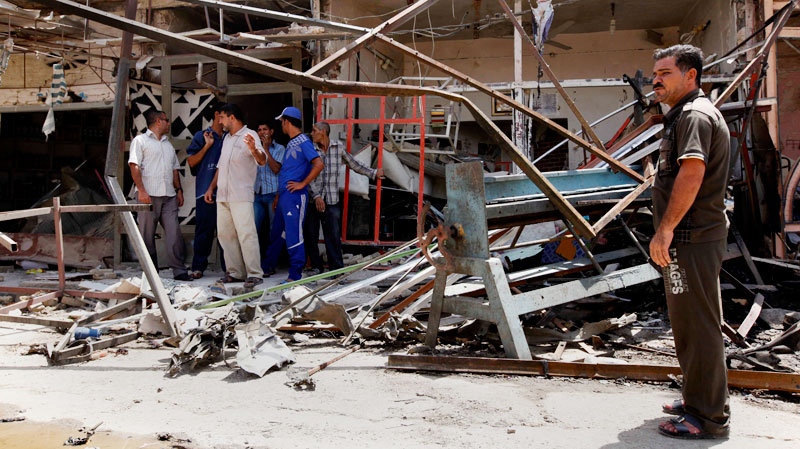 Shop owners inspect their destroyed shop after a car bomb in Kut, Iraq, Monday, Aug. 15, 2011. (AP / Hadi Mizban)