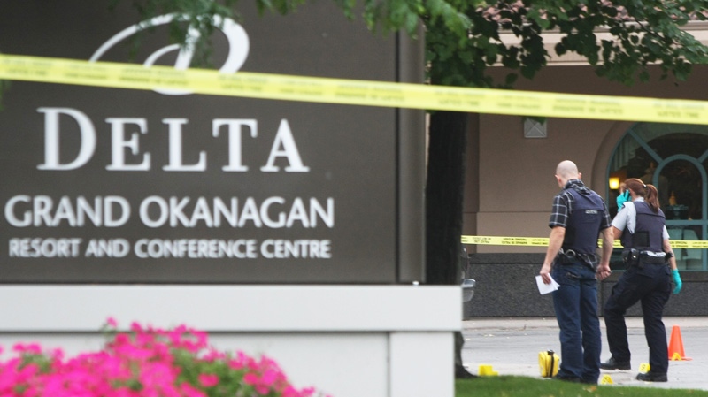 RCMP officers investigate the scene after a masked gunman open fire on a luxury car outside an upscale hotel in a tourist area of Kelowna, B.C., on Sunday, Aug. 14, 2011.  (Chris Stanford / THE CANADIAN PRESS)