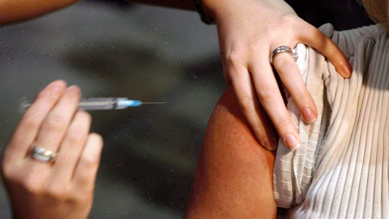 A patient gets a shot during a flu vaccine program in Calgary on Oct. 26, 2009. (Jeff McIntosh / THE CANADIAN PRESS)