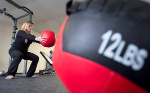 General manager Brianne Angus does squats holding a medicine ball at Downsize Fitness in Orleans, Ont., Tuesday, Dec. 17, 2013. (Adrian Wyld / THE CANADIAN PRESS)