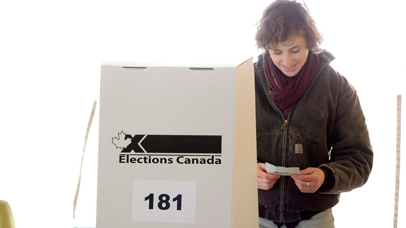 A woman examines her ballot card as she prepares to cast her vote for the federal election in a polling station on Toronto's Ward Island on Monday, May 2, 2011. (Chris Young / THE CANADIAN PRESS)