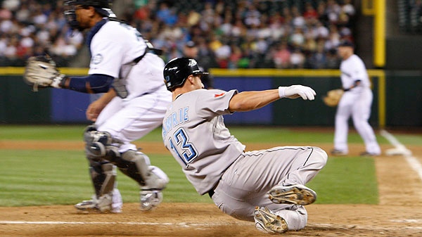 Seattle Mariners' catcher Miguel Olivo waits for the throw to the plate as Toronto Blue Jays' Brett Lawrie scores in the fifth inning during a baseball game in Seattle, on Tuesday, August 16, 2011. Toronto defeated Seattle 13-7. (AP Photo/Kevin P. Casey)