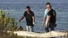 In this picture taken Wednesday Aug. 3, 2011, Gary V. Giordano, left, speaks with Aruban police detectives as they search for his travel partner Robyn Gardner, 35, of Frederick, Md., at Baby Beach in the southern tip of the Caribbean island. (AP Photo/Elton Malone)