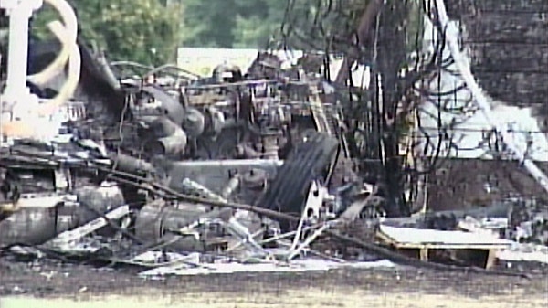 The burned wreckage of a tractor trailer is seen following a crash near Chatham, Ont. on Friday, Aug. 19, 2011.