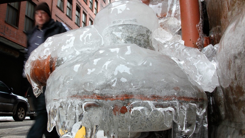 A man walks by a frozen water pipe in downtown Cleveland on Friday, Feb. 11, 2011. (AP Photo/Amy Sancetta)