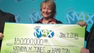 Kathryn Jones holds up a cheque for $50-million in Toronto on Tuesday, Jan. 7, 2014.