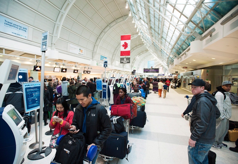 Passengers line-up during flight delays and cancellations due to extreme cold weather at Pearson International Airport in Toronto on Tuesday January 7, 2014. (THE CANADIAN PRESS/Aaron Vincent Elkaim)