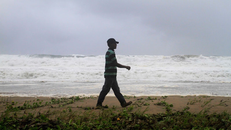 A resident walks along Los Yayales beach as strong waves crash due to the approach of Hurricane Irene to Nagua, in the northern coast of the Dominican Republic, Monday, Aug, 22, 2011. (AP / Roberto Guzman)