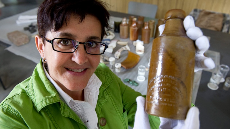 Louise Pothier, director of exhibitions at Montreal's Pointe-a-Calliere archeological and history museum, holds up a beer bottle found in the remains of what was supposed to have been the first permanent parliament of what was then the United Province of Canada, Monday, Aug. 22, 2011 in Montreal. (Paul Chiasson / THE CANADIAN PRESS)