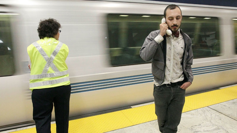 Tom Comitta holds a phone handset up while protesting at the BART Civic Center sttation in San Francisco on Aug. 15, 2011. (AP / Jeff Chiu)