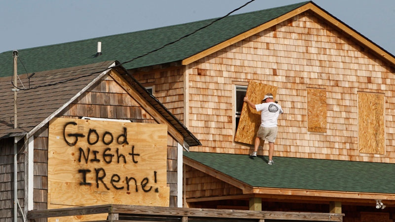 A message is left for Hurricane Irene on one house, left, as a resident boards up another in anticipation of the arrival of Hurricane Irene in Nags Head, N.C., Thursday, Aug. 25, 2011 on North Carolina's Outer Banks. (AP / Charles Dharapak)