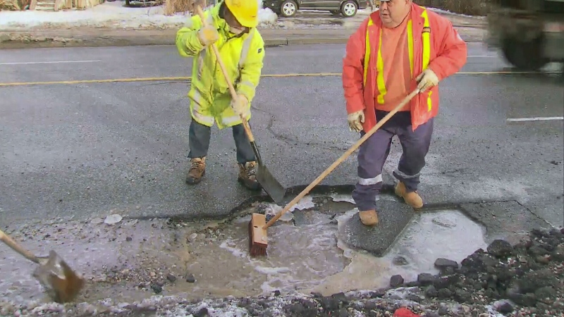 A city crew works to repair a pothole in Toronto, Monday, Jan. 13, 2014. 