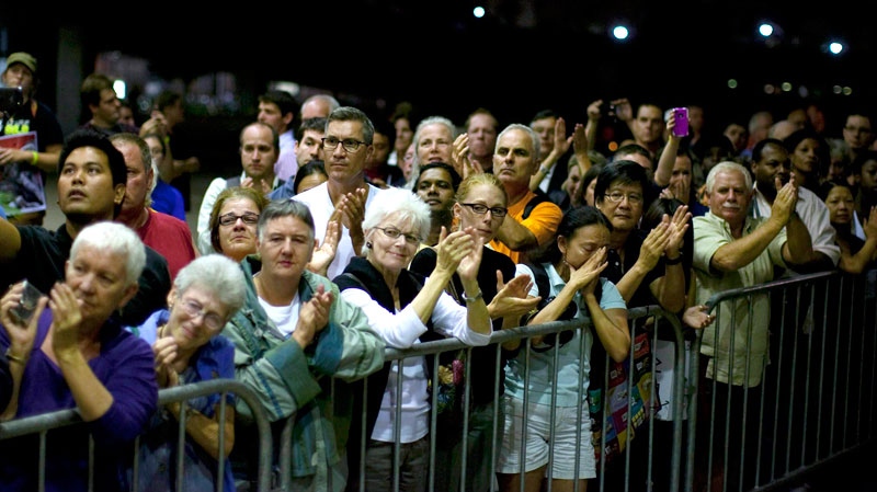 Crowds applaud as the casket containing Jack Layton arrives at Toronto City Hall, late Thursday, Aug. 25, 2011. (Chris Young / THE CANADIAN PRESS)  