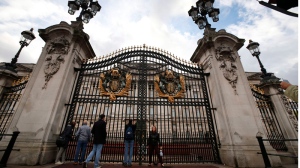 Tourists gather at the area in front of Buckingham Palace in central London, Monday, Oct. 14, 2013. (AP / Lefteris Pitarakis)