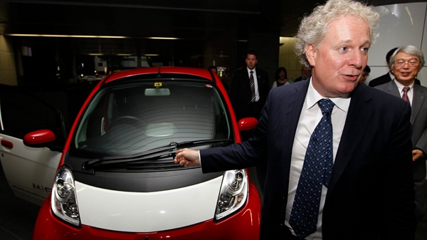 Canada's Quebec Premier Jean Charest talks about his impression on Mitsubishi Motors iMiEV after riding in a passenger seat of the electric vehicle at the company's headquarters in Tokyo Friday, Aug. 26, 2011. At right is Mitsubishi Motors Corp. Executive Vice President Gayu Uesugi. (AP Photo/Hiro Komae)