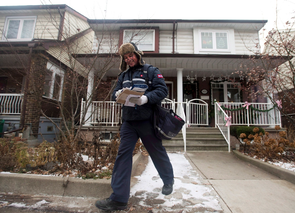 Canada Post employee delivers mail in Toronto