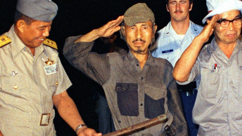 In this March, 1974 photo, Hiroo Onoda, centre, salutes after handing over his military sword on Lubang Island, Philippines, when he comes out of hiding in the jungle. (AP Photo/Kyodo News) JAPAN OUT, CREDIT MANDATORY