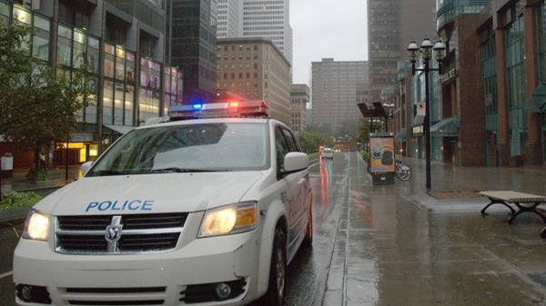 Police block a street in downtown Montreal on Sunday Aug. 28, 2011. Panes of glass from the Rogers building from the 6th and 19th floor fell from the building as Irene reaches the area. THE CANADIAN PRESS/Shaney Komulainen
