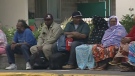 Evacuated residents who live in an apartment building on Donald Street sit on the side of the road, Monday, Aug. 29, 2011. 