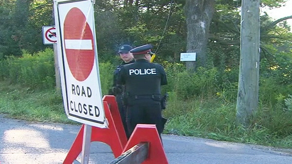 Police are seen at a command post set up after human remains were found near Warden Avenue and Aurora Road in Whitchurch-Stouffville on Tuesday, Aug. 30, 2011.
