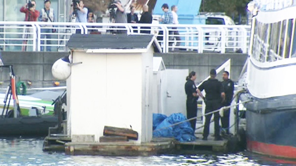 Police investigate after a foot and leg bone were found floating in the water along the shore of Vancouver's False Creek on Tuesday, Aug. 30, 2011. 