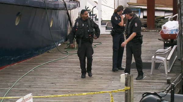 Police investigate after a foot and leg bone were found floating in the water along the shore of Vancouver's False Creek on Tuesday, Aug. 30, 2011. 