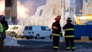 A payloader prepares to move in as flames flare up at the scene of a fatal fire which destroyed a seniors residence in L'Isle-Verte, Que., Thursday, January 23, 2014. THE CANADIAN PRESS/Jacques Boissinot