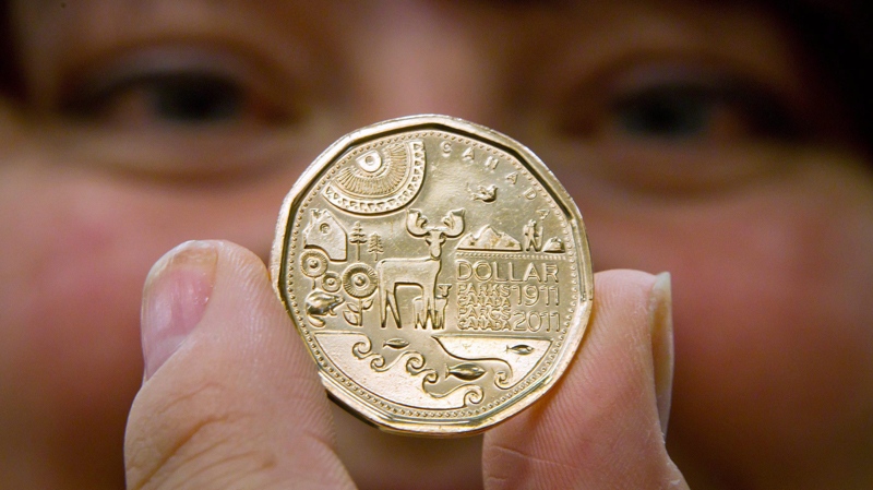 Julie Cossette holds a loonie