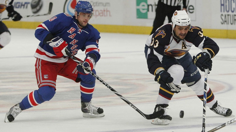 Dustin Byfuglien (right) and the New York Rangers' Marian Gaborik (left) are seen fighting for the puck in this file photo of an NHL game on Thursday, April 7, 2011. (AP Photo/Frank Franklin II)