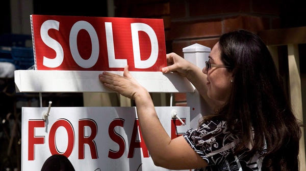 A real estate agent puts up a 'sold' sign in front of a house in Toronto Tuesday, April 20, 2010. (Darren Calabrese / THE CANADIAN PRESS)