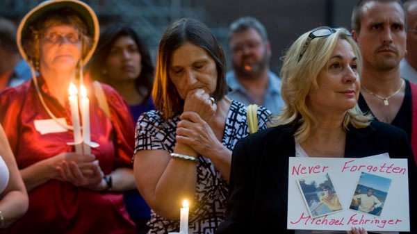 People hold candles at the site where the Bluebird Cafe once stood to commemorate the victims who perished in a fire at the Bluebird in 1972, in Montreal, Thursday, September 1, 2011. THE CANADIAN PRESS/Graham Hughes