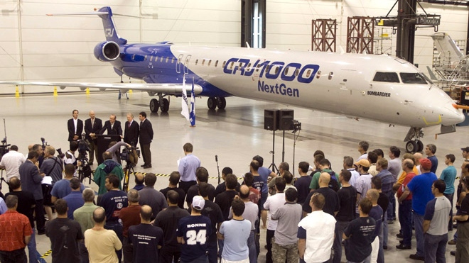 Quebec Premier Jean Charest reacts to Bombardier's approval for the launch of the new CSeries jet, in front of the company's CRJ1000 prototype plane at a news conference in the Bombardier plant in Mirabel, Que., Sunday, July 13, 2008.  (Ryan Remiorz / THE CANADIAN PRESS)