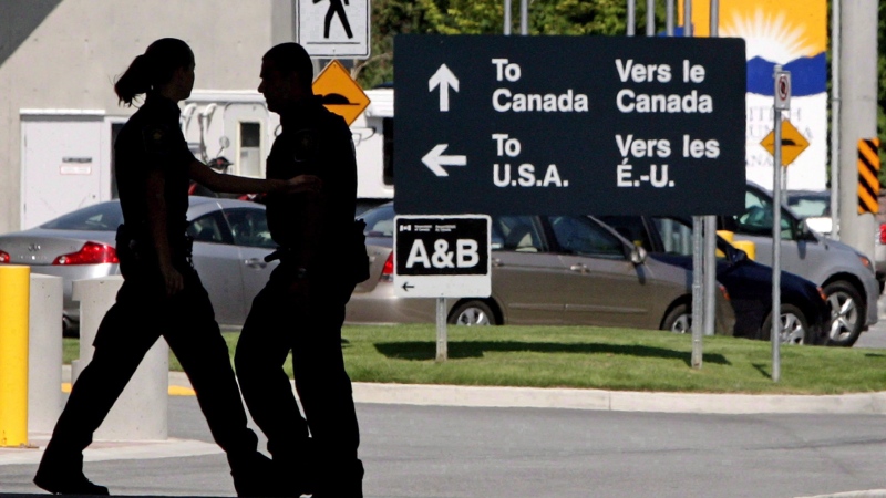 Canadian border guards are silhouetted as they replace each other at an inspection booth at the Douglas border crossing on the Canada-USA border in Surrey, B.C., on Thursday, Aug. 20, 2009. (Darryl Dyck / THE CANADIAN PRESS)