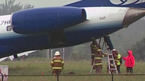 Fire crews work to contain a fuel leak from a United Express plane that skidded off the runway at the Ottawa International Airport Sunday, Sept. 4, 2011.
