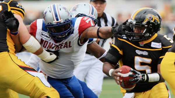 Hamilton Tiger-Cats quarterback Kevin Glenn is grabbed by the face mask by Montreal Alouettes John Bowman during first half Canadian Football League action in Hamilton, Ontario, Monday, September 5, 2011. A penalty was called on the play. THE CANADIAN PRESS/Dave Chidley
