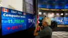 A TV cameraman films the numbers on the TSX board showing the continued tumble at the TMX in Toronto on Monday morning, August 8 2011. (Aaron Vincent Elkaim / THE CANADIAN PRESS)