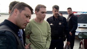Luka Rocco Magnotta is taken by police from a Canadian military plane to a waiting van in Mirabel, Que., on Monday, June 18, 2012. (Montreal Police)