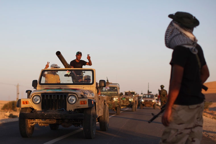 Former rebel fighters celebrate as they pass by a checkpoint near Bani-Walid, Libya, Monday, Sept. 12, 2011. (AP / Alexandre Meneghini)