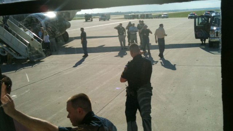 This photo provided by Joey Mentzer, passengers are escorted off an Frontier Airlines plane on Sunday, Sept. 11, 2011 at Detroit's Metropolitan Airport. 
